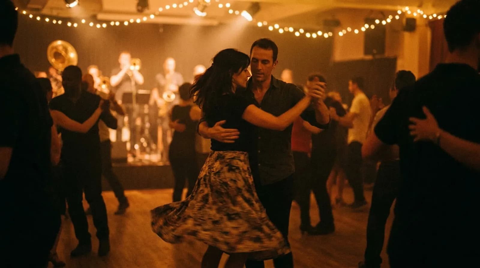 Pareja bailando salsa en una noche latina de Londres, con la banda al fondo